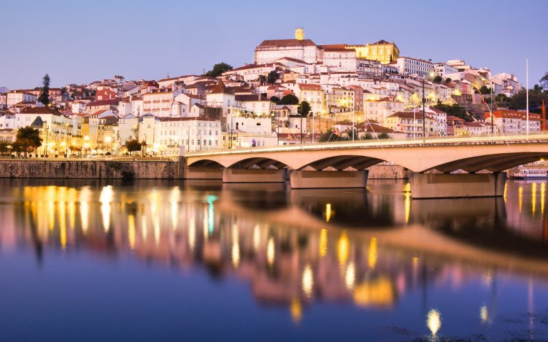 View Of Coimbra In Portugal And Mondego River At Night
